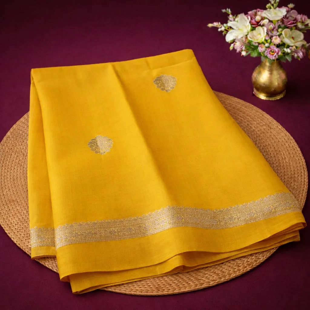 Luxurious Pure Banarasi Raw Mango Handloom Saree in vibrant yellow with intricate gold zari border, ideal for festive occasions.
